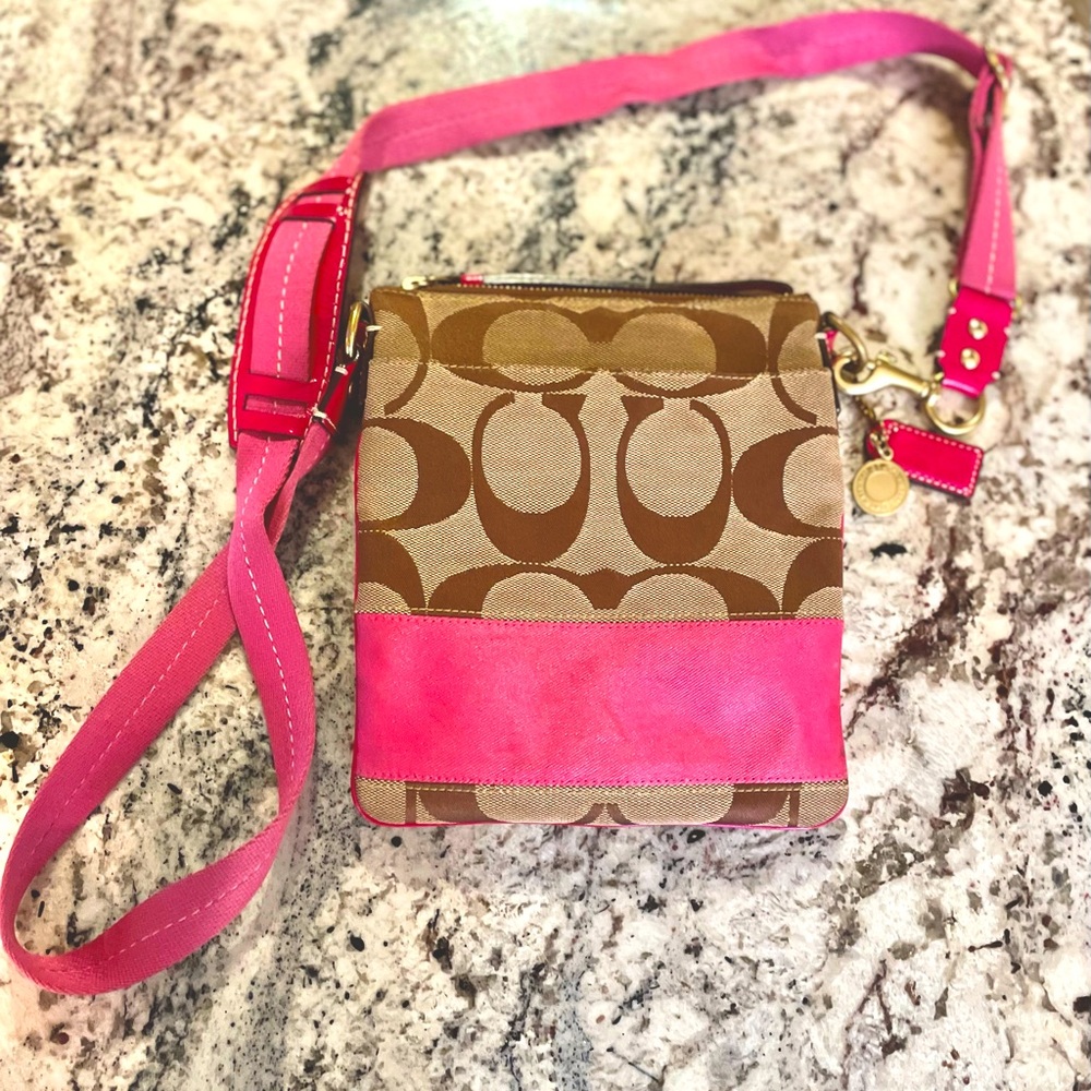Coach crossbody bag in signature canvas with pink accent color.